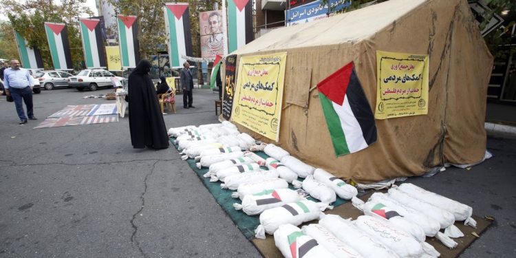 People stand near mock objects symbolising dead children during a campaign to collect donations for Palestinians in Gaza at Palestine Square in Tehran, Iran. [Abedin Taherkenareh/EPA]