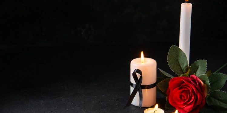 front-view-burning-candle-with-red-flower-dark-surface_
