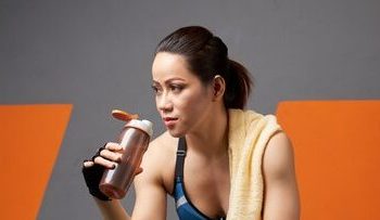 full-length-athlete-sipping-water-from-fitness-bottle-exhausted-