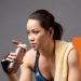 full-length-athlete-sipping-water-from-fitness-bottle-exhausted-