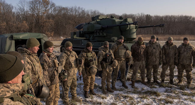 Ukrainian servicemen of a drone hunting team gather next to German Gepard anti-aircraft-gun tank that is used to target Russian launched drones, in the outskirts of Kyiv,