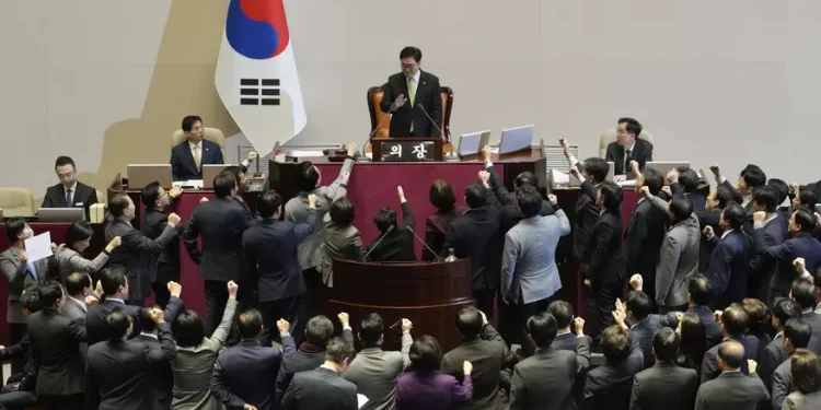 Lawmakers of the ruling People Power Party protest to South Korea's National Assembly Speaker Woo Won-shik, top center, during a plenary session for the impeachment motion against South Korean acting President Han Duck-soo at the National Assembly in Seoul, South Korea, Friday, Dec. 27, 2024.
