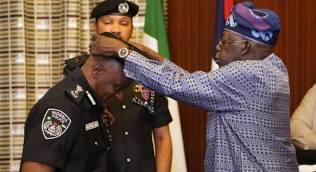 President Bola Ahmed Tinubu decorating AIG Tunji Disu during a ceremony at the Presidential Office in State House, Abuja