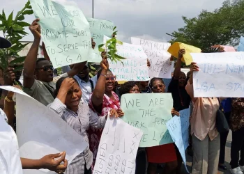 C'River local govt workers protesting workers carrying  placards with various inscriptions