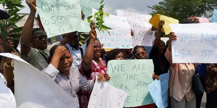 C'River local govt workers protesting workers carrying  placards with various inscriptions