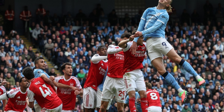 Manchester City's Norwegian striker #09 Erling Haaland (R) heads the ball in front of goal during the English Premier League football match between Manchester City and Arsenal at the Etihad Stadium in Manchester, north west England