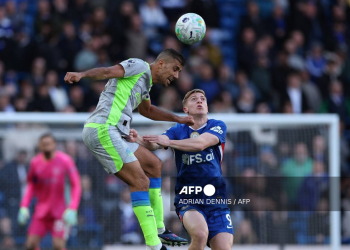 Manchester City's Spanish midfielder #16 Rodri (L) jumps with Chelsea's English striker #09 Liam Delap during the English Premier League football match between Chelsea and Manchester City at Stamford Bridge in London on April 12, 2026.