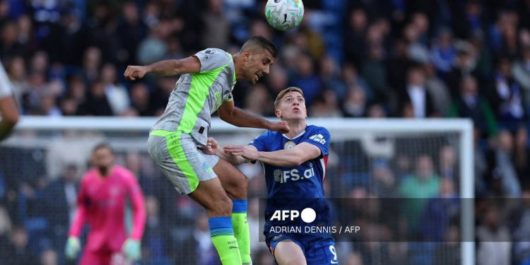 Manchester City's Spanish midfielder #16 Rodri (L) jumps with Chelsea's English striker #09 Liam Delap during the English Premier League football match between Chelsea and Manchester City at Stamford Bridge in London on April 12, 2026.
