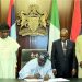 President Tinubu signs NIMC Bill into law watched by lawmakers and NIMC officials.