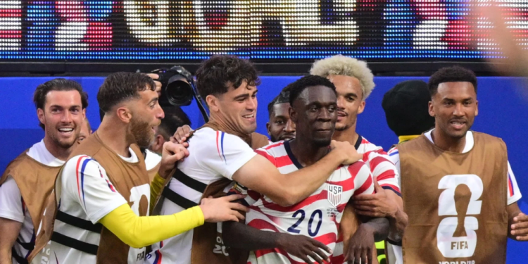 US forward #20 Folarin Balogun, C, celebrates scoring his team's third goal with teammates during the 2026 World Cup Group D football match between USA and Paraguay at the Los Angeles Stadium in Inglewood on June 12, 2026
