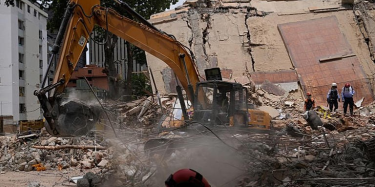 Workers clear debris from a collapsed building in Caracas, Venezuela