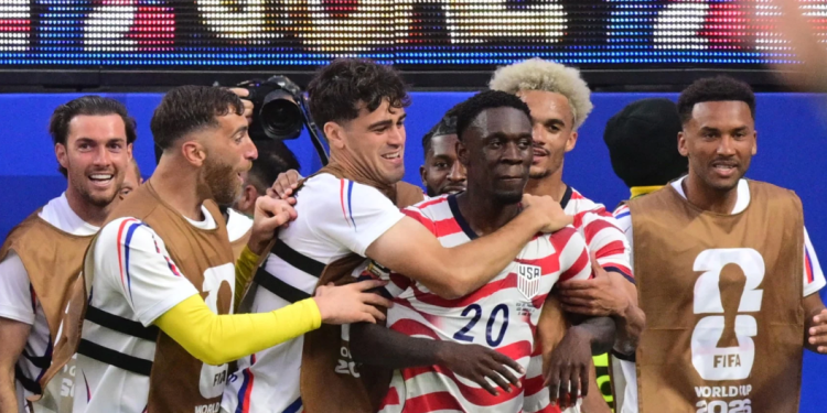 US forward #20 Folarin Balogun celebrates scoring his team's third goal with teammates during the 2026 World Cup Group D football match between USA and Paraguay