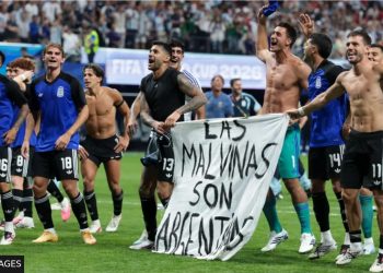 Argentine players display a banner making claims to Falklands Islands against FIFA rules.