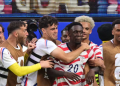 US forward #20 Folarin Balogun, C, celebrates scoring his team's third goal with teammates during the 2026 World Cup Group D football match between USA and Paraguay at the Los Angeles Stadium in Inglewood on June 12, 2026