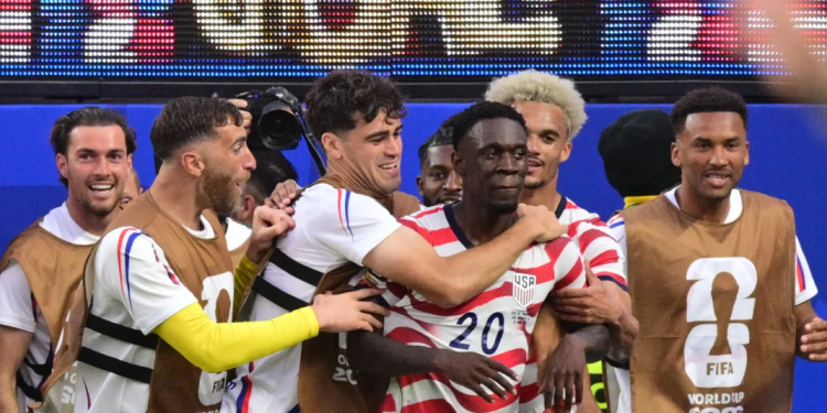 US forward #20 Folarin Balogun, C, celebrates scoring his team's third goal with teammates during the 2026 World Cup Group D football match between USA and Paraguay at the Los Angeles Stadium in Inglewood on June 12, 2026