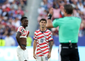 Balogun standing with Pulisic awaiting the ref verdict after a VAR check on an infraction