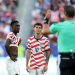 Balogun standing with Pulisic awaiting the ref verdict after a VAR check on an infraction