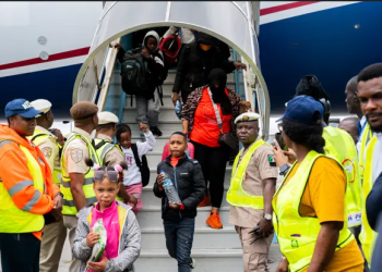 Nigerian government officials receive the 308 returnees disembarking from the aircraft