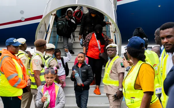 Nigerian government officials receive the 308 returnees disembarking from the aircraft