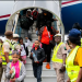 Nigerian government officials receive the 308 returnees disembarking from the aircraft