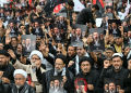 Shia Muslims holding portraits of Iran's Supreme Leader Mojtaba Khamenei and late leader Ali Khamenei