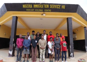 Twelve suspects arrested by the Nigeria Immigration Service stand outside the agency's Migrant Holding Centre