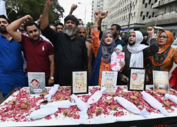 Human rights activists hold a candlelight vigil to mourn the deaths of newborns killed in a hospital fire in Pakistan this week