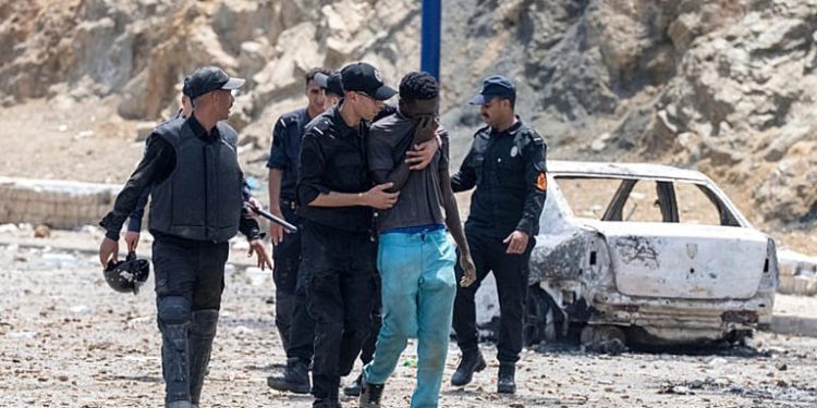 Moroccan security forces detain a man who was trying to cross from Fnideq into the Spanish enclave of Ceuta