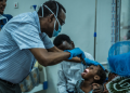 A pediatrician examines a young child’s throat and tonsils as Kano State moves to contain reported diphtheria outbreak.