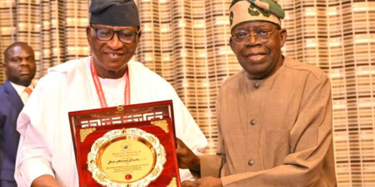 President Bola Tinubu presents a commemorative plaque to a recipient during a presentation ceremony at the Presidential Villa, Abuja.