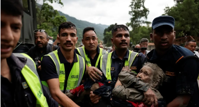 Rescue team members carry an elderly survivor to safety following devastating flash floods and landslides in Nepal.
