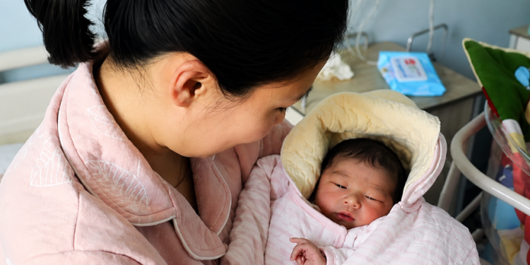 Tender mother and newborn cuddle