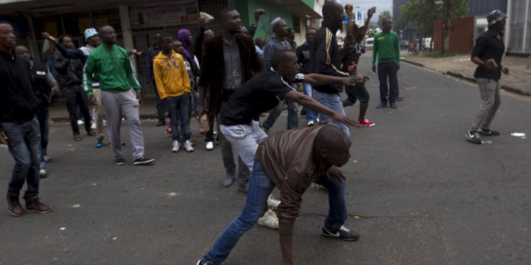 A group of foreign nationals threaten to defend themselves as police get between them and South Africans after a peace march in Durban