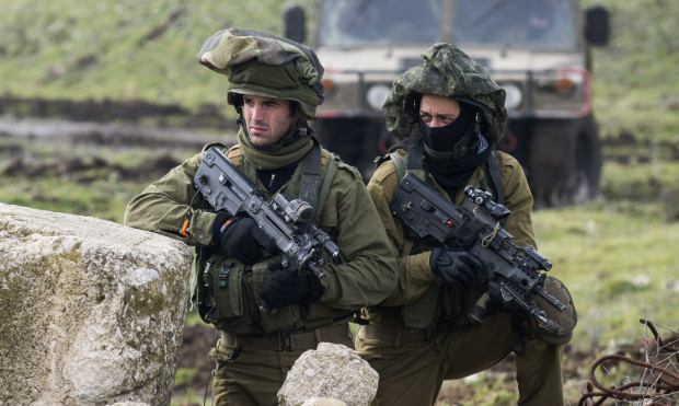 Israeli military troops operate near the Gaza border as the country’s prolonged regional conflicts drive rising defence spending and fuel a dispute over military funding.