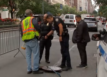 Police investigate a manhole near a Manhattan hotel after two men are arrested for allegedly entering New York City’s underground sewer system in search of valuables during the United Nations General Assembly.