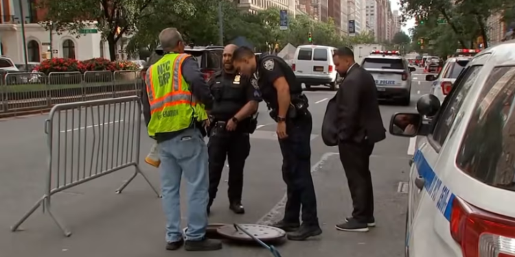 Police investigate a manhole near a Manhattan hotel after two men are arrested for allegedly entering New York City’s underground sewer system in search of valuables during the United Nations General Assembly.