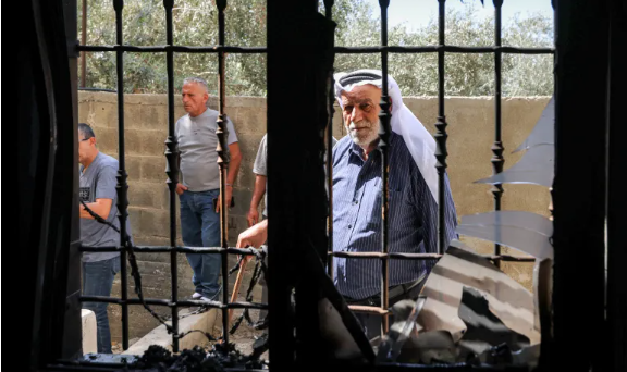 Palestinians inspect a mosque that was attacked by Israeli settlers in the Palestinian village of Bazariya, in the occupied West Bank