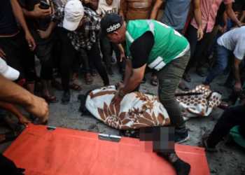 People tend to the deceased after an Israeli strike targeted a group of Palestinians in Gaza City on Thursday