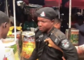 A police officer is surrounded by traders and other people during a confrontation at Watt Market in Calabar, Cross River State.