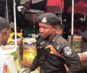 A police officer is surrounded by traders and other people during a confrontation at Watt Market in Calabar, Cross River State.