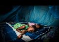 Children sleeping under a mosquito net