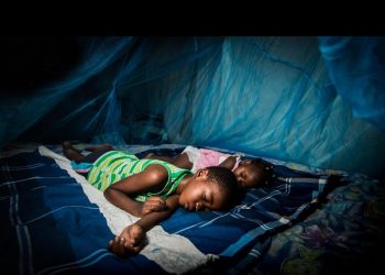 Children sleeping under a mosquito net