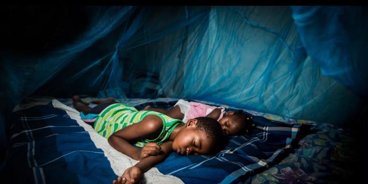 Children sleeping under a mosquito net