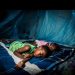 Children sleeping under a mosquito net