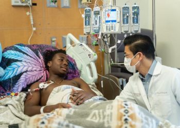 A healthcare professional providing care to a patient in a hospital.