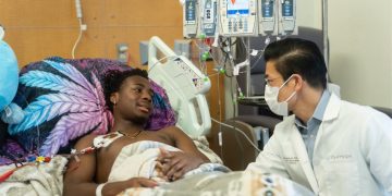 A healthcare professional providing care to a patient in a hospital.