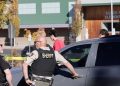 Local police officers stand beside their vehicles outside Silver Rail Elementary School following a deadly shooting in Oregon. (photo credit: BBC News)