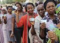 Nigerians display their Permanent Voter Cards after voter registration.