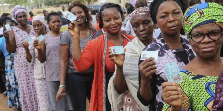 Nigerians display their Permanent Voter Cards after voter registration.