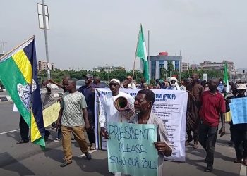 Retired Nigerian police officers hold a banner during a protest over the contributory pension scheme.